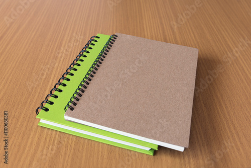 Blank hard cover Spiral notebook on wooden table background.

 photo