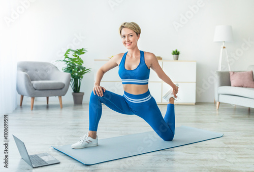 Warming Up Before Workout. Smiling Fit Woman Training In Living Room At Home, Beautiful Female Stretching Legs Doing Low Lunge With Quad Stretch, Cooling Down After Exercises On Mat, Free Space