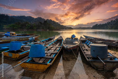 Fisherman boats docked peacefully along the calm waters of Gubir Lake at Sik Kedah, bathed in the soft glow of the morning light. A serene moment of lakeside beauty.