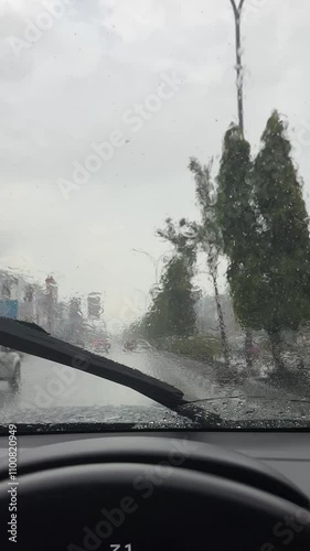 footage of driving in heavy rain and wipers wiping the glass