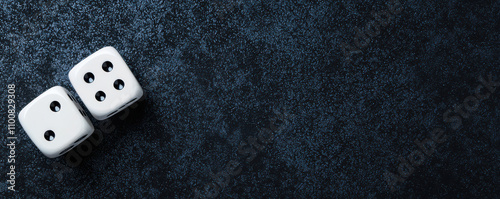 Two white dice on dark textured surface, symbolizing chance and risk
