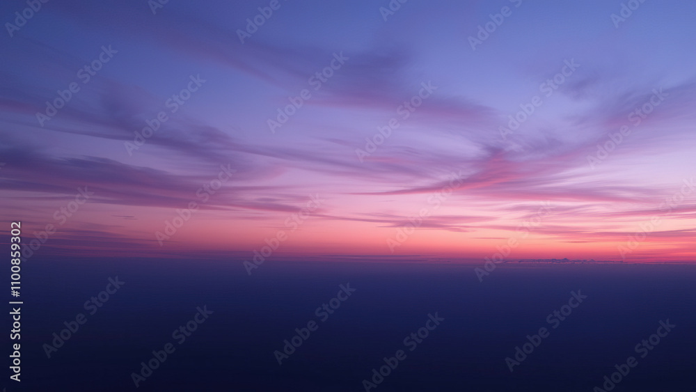 Fototapeta premium Dusk sky with gradient purple and blue hues, soft clouds drifting across the horizon, gradient sky, twilight scene., serene atmosphere, outdoor scenery, soft clouds