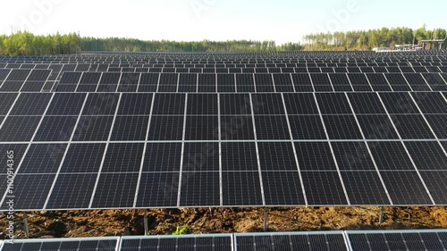 Aerial low dolly over of Solar Farm highlighting rows of bifacial solar panels sweeping out to horizon photo