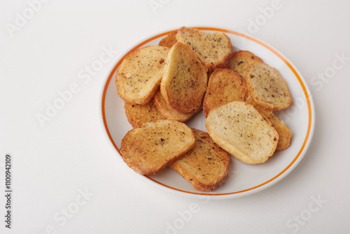 Top view of crispy bread crackers on plate on white background