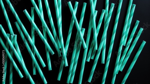 Aqua and black striped straws scattered on a dark background minimalistic design concept creative flat lay with empty space for text photo