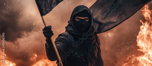 Masked young man in black attire holding a flag amidst fiery chaos during a protest symbolizes dissent and social upheaval.
