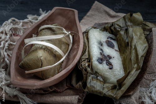 Obraz na płótnie Khao tom mat, a Laotian and Thai dessert of seasoned steamed sticky rice wrapped in banana leaves normally inserted with filling made of banana and black beans for special occasions or merit making. w salonie