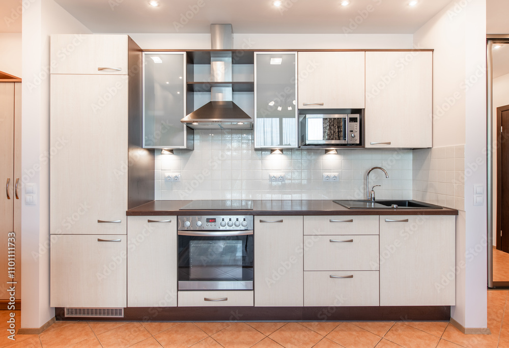 Fototapeta premium Scandinavian Style Cozy Modern Open Bright Kitchen Home Interior. Faucet, Fridge, Microwave, Stove, Oven, Cooker Hood and Furniture in Background.