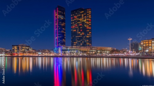 Vibrant Nighttime Cityscape of Modern Skyscrapers Reflected in Calm Water with Colorful Lights Illuminating the Scene in an Urban Environment