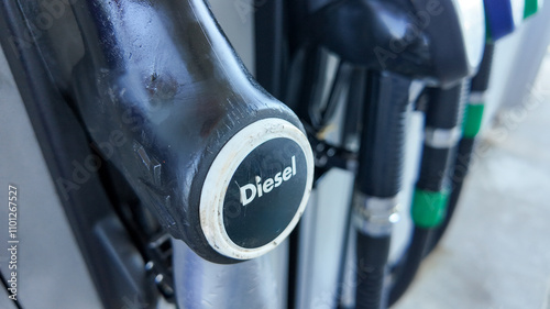 Close-up of a diesel pump nozzle at a gas station, highlighting fuel choices related to environmental impact and energy consumption