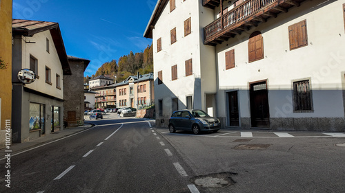 A quiet street in an Italian mountain village on a sunny day, depicting serene rural life in Europe