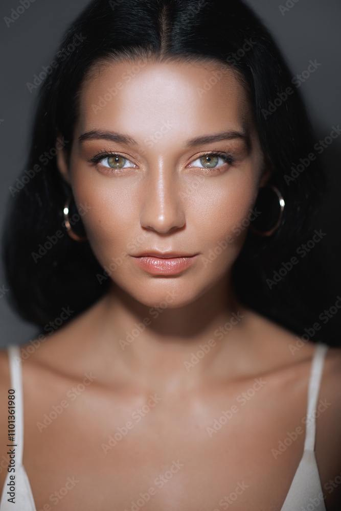 Obraz premium A close-up of a woman with flawless skin and an intense gaze, highlighting her radiant complexion and natural beauty. Perfect for beauty, skincare, and cosmetic product advertisements or tutorials.