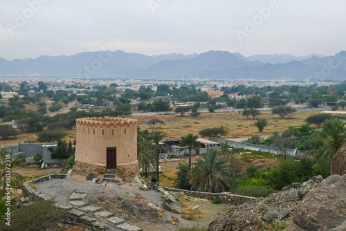 Watch Tower on blurred cloudy mountains background next to historical oldest AL Bidyah Mosque, Fujairah. UAE .Popular touristic weekend travel destination.