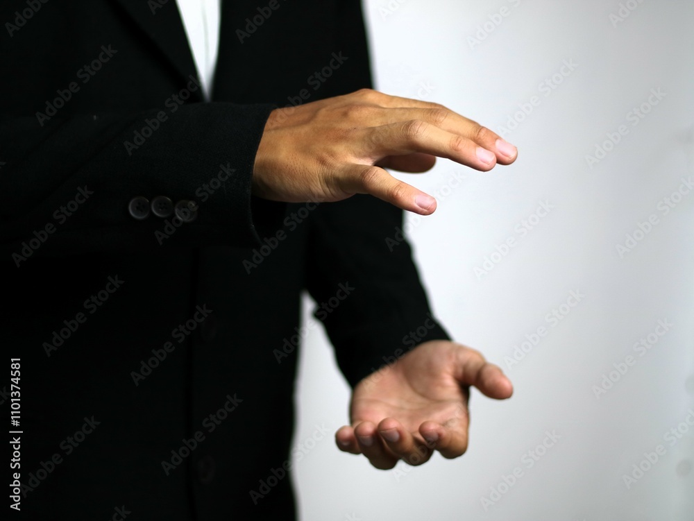 Fototapeta premium A confident hand in a sleek black suit gestures animatedly, illustrating a strategic business concept such as focus, collaboration, goal setting, time management, networking, emphasizing collaboration