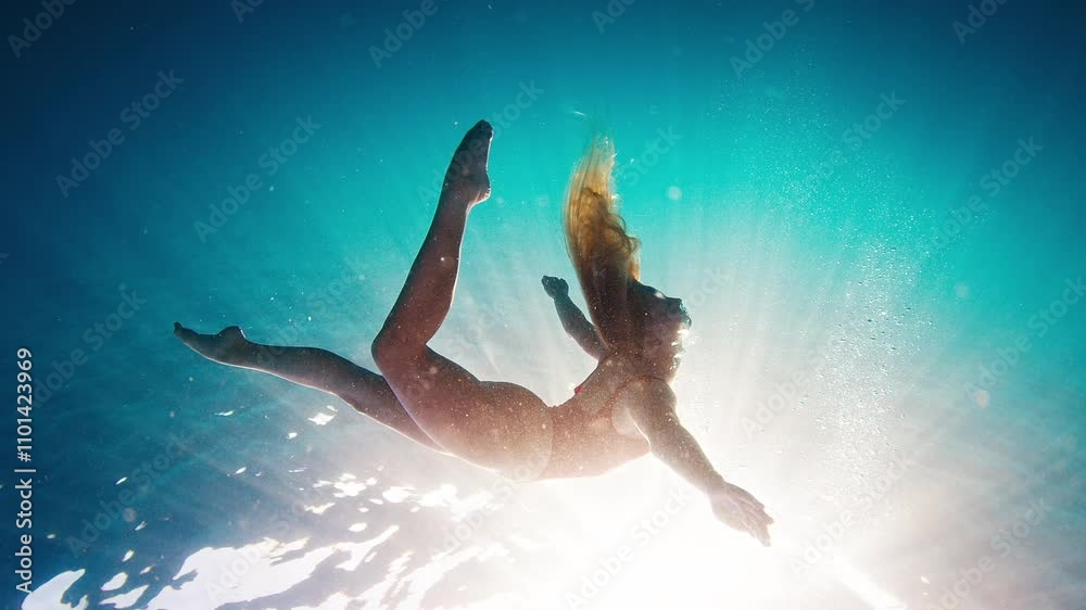 Teen girl in red suit dives and swims confidently underwater in the crystal clear tropical sea. Extreme slow motion footage Teen girl in red suit dives and swims confidently underwater in the crystal clear tropical sea. Extreme slow motion footage