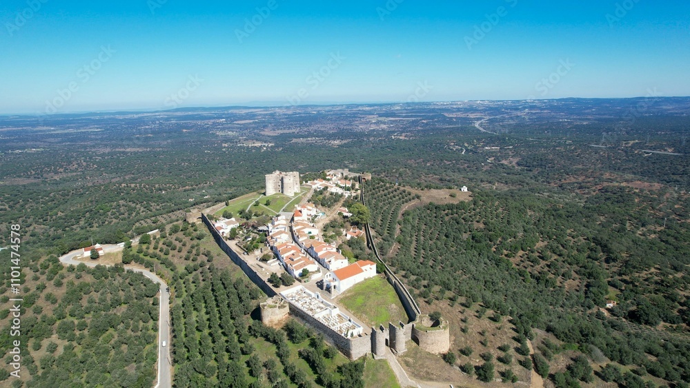 Obraz premium Aerial view of Evoramonte Castle and surrounding landscape in Alentejo, Portugal, under a blue sky