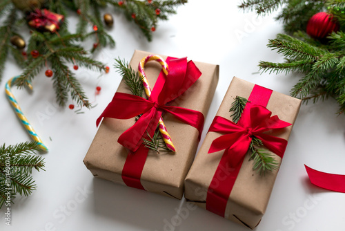 Christmas gifts in craft paper and tied with a red ribbon. Christmas gift wrapping using eco-friendly materials and pine branches