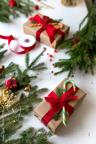 Christmas gifts in craft paper and tied with a red ribbon. Christmas gift wrapping using eco-friendly materials and pine branches