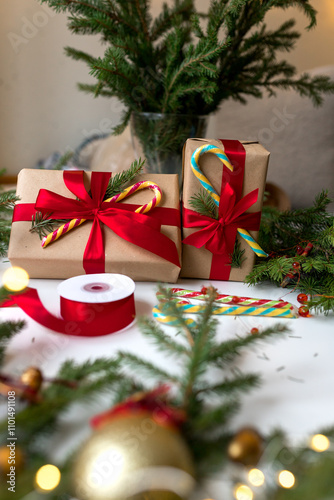 Christmas gifts in craft paper and tied with a red ribbon. Christmas gift wrapping using eco-friendly materials and pine branches