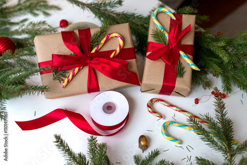 Christmas gifts in craft paper and tied with a red ribbon. Christmas gift wrapping using eco-friendly materials and pine branches