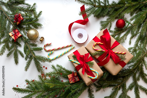 Christmas gifts in craft paper and tied with a red ribbon on the white table. Christmas gifts wrapping using eco-friendly materials and pine branches