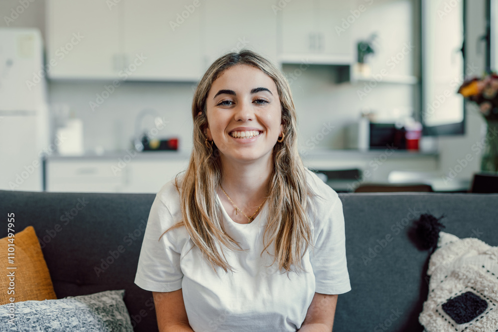 Close up overjoyed woman laughing, sitting on couch at home, head shot portrait young female chatting online with friends or relatives, looking at camera, having fun, making call or shooting video.