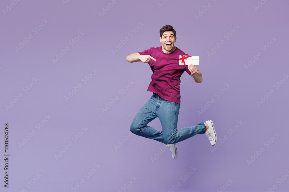 Full body young man wear violet t-shirt casual clothes hold point on gift certificate coupon voucher card for store isolated on plain pastel light purple background studio portrait. Lifestyle concept.