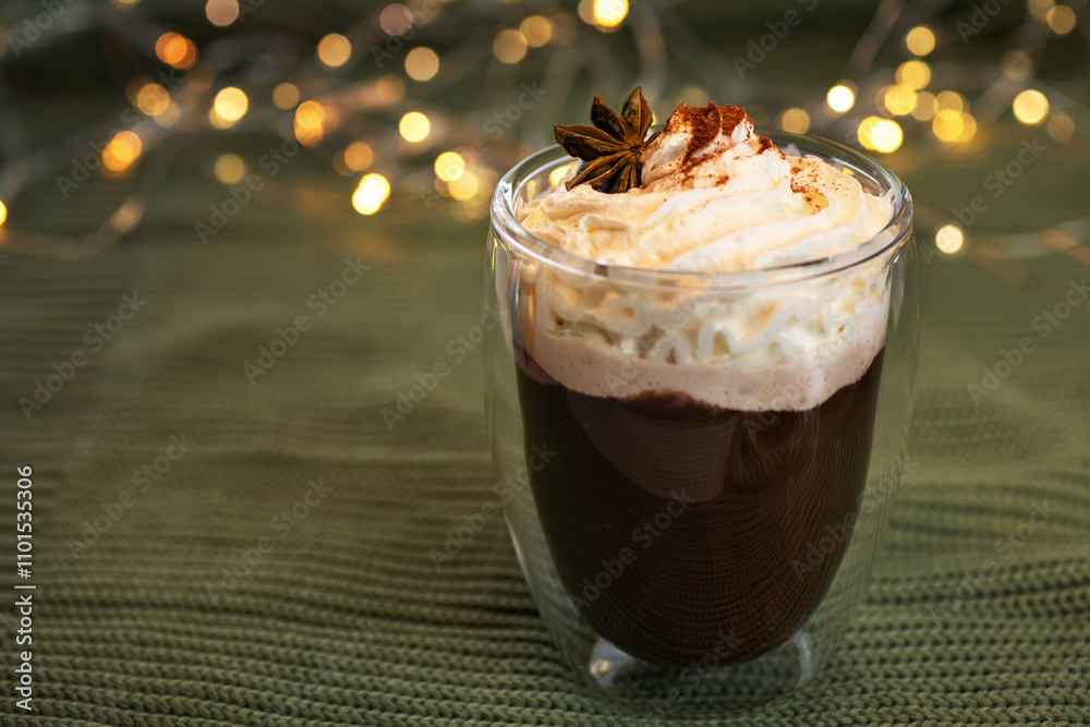 Φωτογραφία Coffee with whipped cream and spices in a glass with double walls on a bokeh background