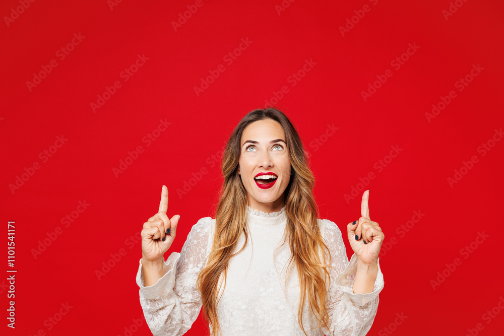 Young happy surprised shocked Caucasian woman wear white blouse casual clothes point index finger overhead on empty area mock up isolated on plain red background studio portrait. Lifestyle concept. Young happy surprised shocked Caucasian woman wear white blouse casual clothes point index finger overhead on empty area mock up isolated on plain red background studio portrait. Lifestyle concept.