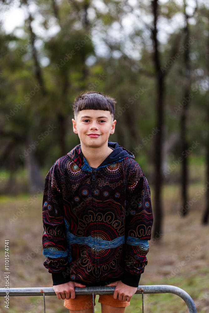 Aboriginal kid leaning on fence in paddock in winter Aboriginal kid leaning on fence in paddock in winter