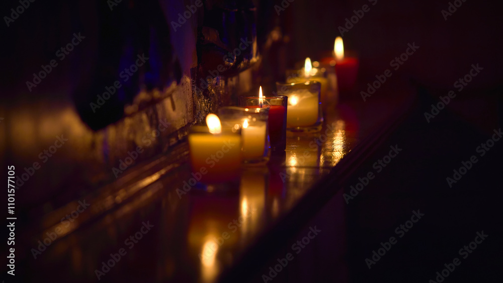 red and yellow decorative candles in glasses on a shelf red and yellow decorative candles in glasses on a shelf