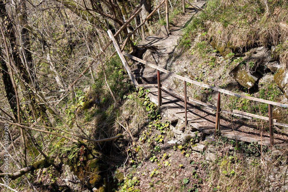 A wooden bridge over a rocky path with moss growing on the rocks A wooden bridge over a rocky path with moss growing on the rocks