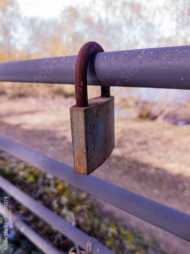 Old padlock on metal fence