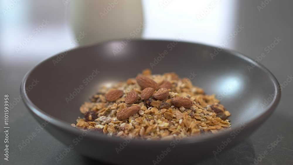 Enjoy a delicious bowl of granola generously topped with nuts and a variety of dried fruits, ideal for breakfast Enjoy a delicious bowl of granola generously topped with nuts and a variety of dried fruits, ideal for breakfast