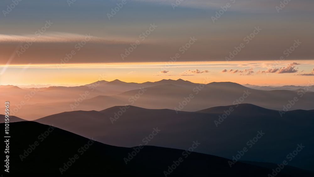 Layers of mountains under a warm pink and orange sunset glow Layers of mountains under a warm pink and orange sunset glow