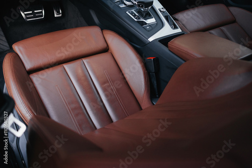 Modern brown car interior, leather steering wheel, climate control, navigation, air ducts, deflectors on the car panel, interior details. photo