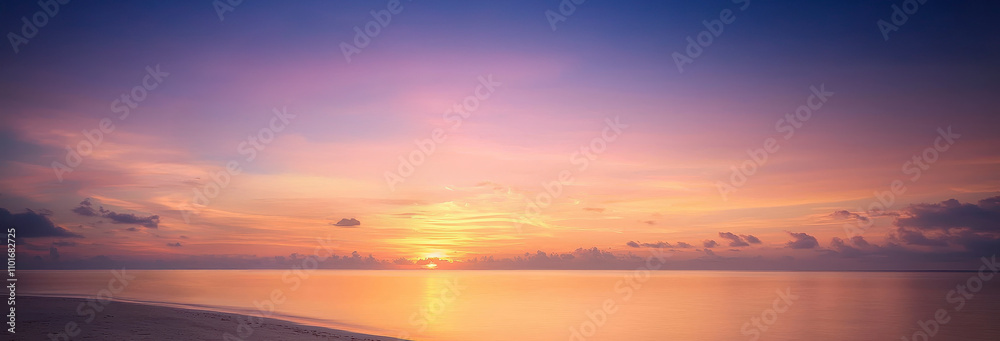 Fototapeta premium A serene sunset over calm waters, showcasing vibrant colors of orange, pink, and purple blending beautifully in the sky.