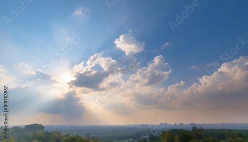 The bright blue sky illuminated by the warm sunlight, showcasing a serene scene with both small and large clouds alternating in patterns, creating a stunning natural atmosphere of beauty.