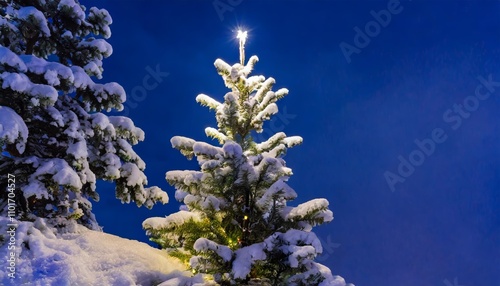 A Majestic Snow-Covered Christmas Tree Stands in Serene Contrast Against a Dark Blue Backdrop, Embodying Winterâ€™s Magic and Festive Spirit in a Peaceful, Dreamlike Landscape. photo