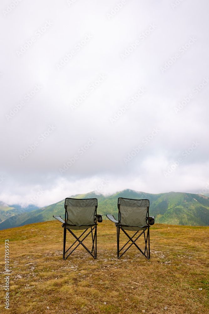 Camping chairs and misty mountains. Camping concept vertical photo Camping chairs and misty mountains. Camping concept vertical photo