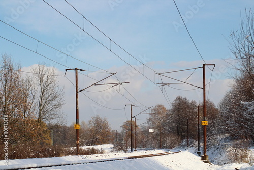 Winter landscape with snow covered rails on a road railway in a snowy scene on the horizon 