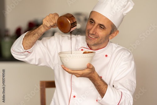 Pastry chef cook pours melted chocolate from golden pot into a bowl