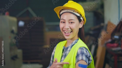 Factory woman worker or technician with safety uniform hold tablet and smile stand in workplace in front of machine. Concept of good management system help to support industrial business.	

