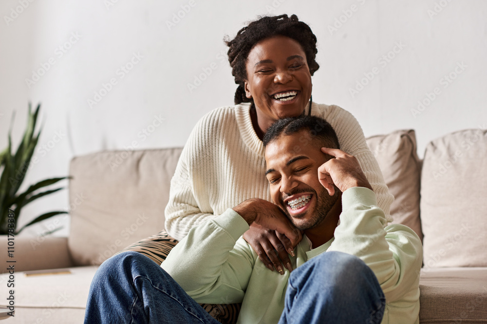 A couple enjoys quality time together, laughing and embracing while cozy indoors during winter. A couple enjoys quality time together, laughing and embracing while cozy indoors during winter.