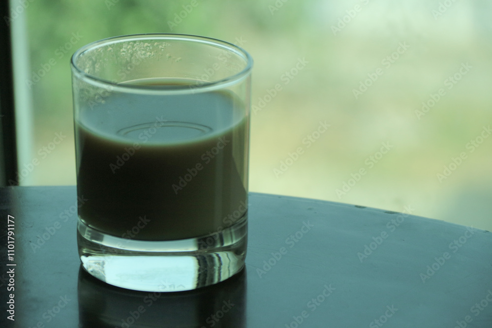 Transparent double wall glass, with black coffee, on white background. Cup with black liquid on white rotating table. Transparent double wall glass, with black coffee, on white background. Cup with black liquid on white rotating table.