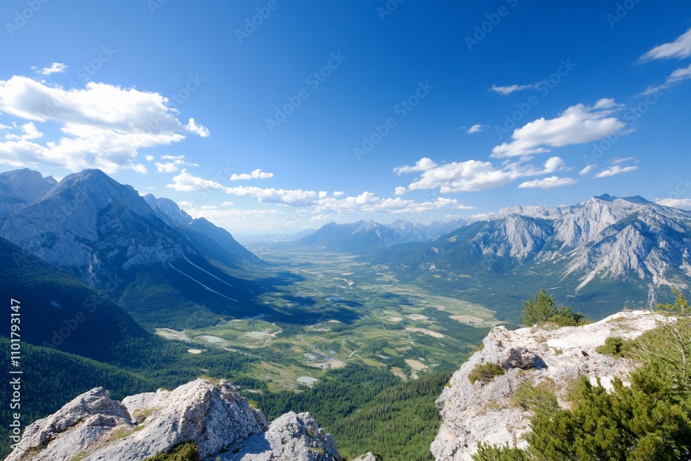 Obraz premium Panoramic view of a valley nestled between majestic mountains under a bright, sunny sky.