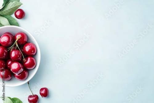 Fresh cherries glistening with water droplets in a silver bowl during a summe...