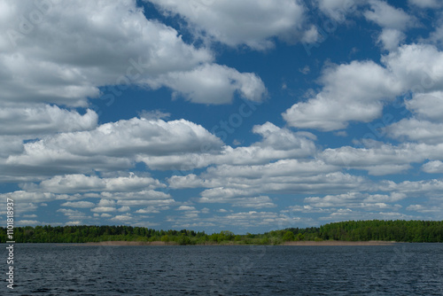 The lake during the summer in sunny warm weather with soft white clouds.