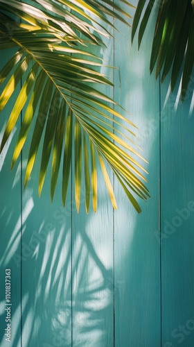 Palm leaves casting shadows on a blue wooden background in bright daylight