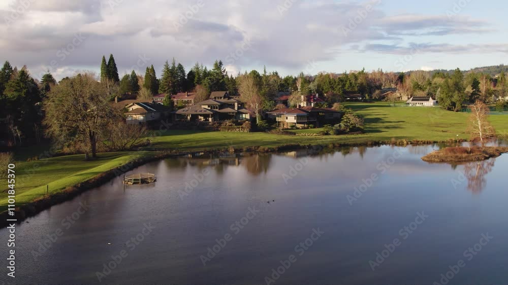 Drone shot gliding over a serene lake, capturing views of upscale homes and a pristine golf course. Drone shot gliding over a serene lake, capturing views of upscale homes and a pristine golf course.